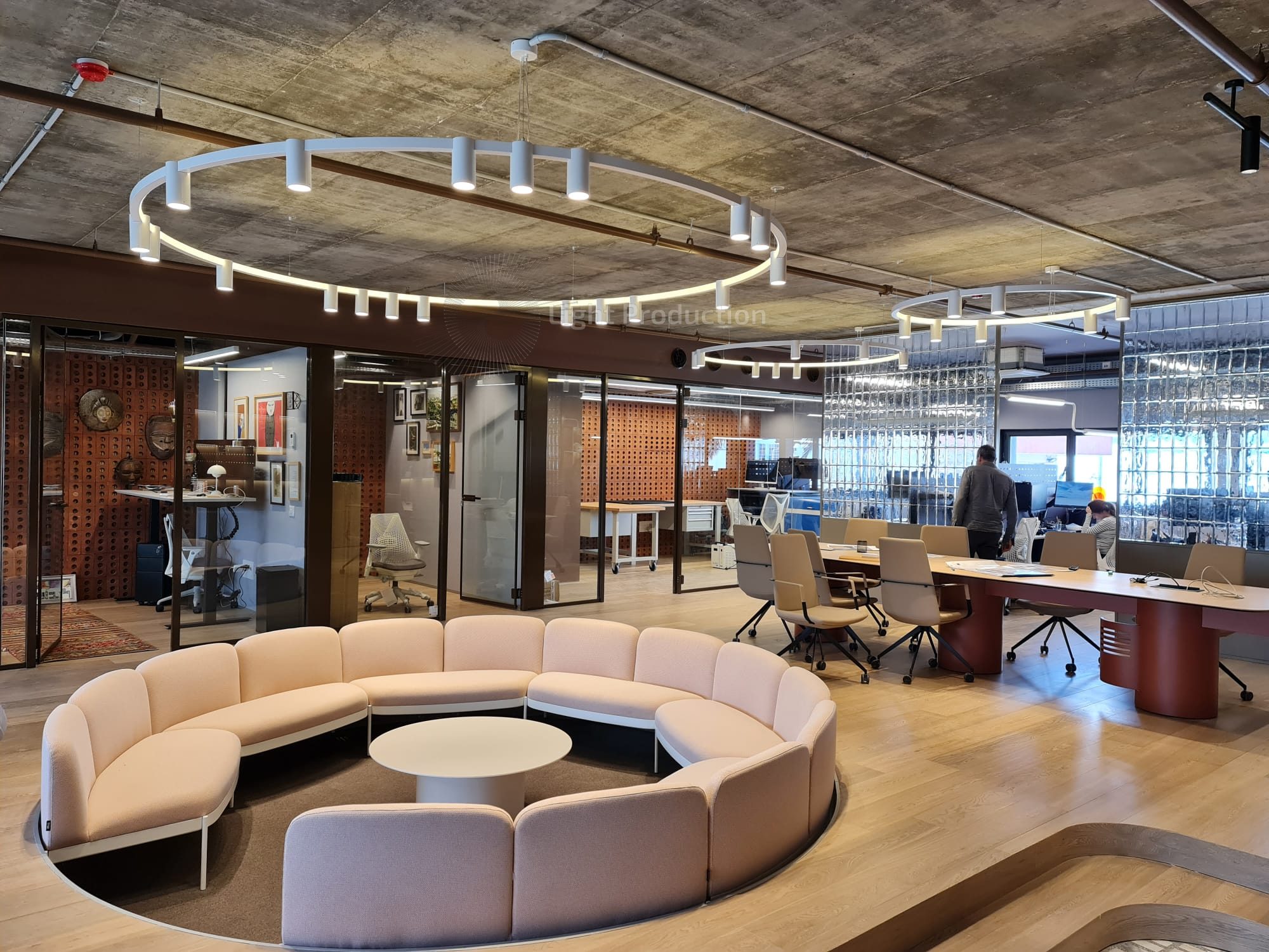 גופי תאורה עגולים צמודי תקרה תויים במשרד מעל פינות ישיבה ועבודה