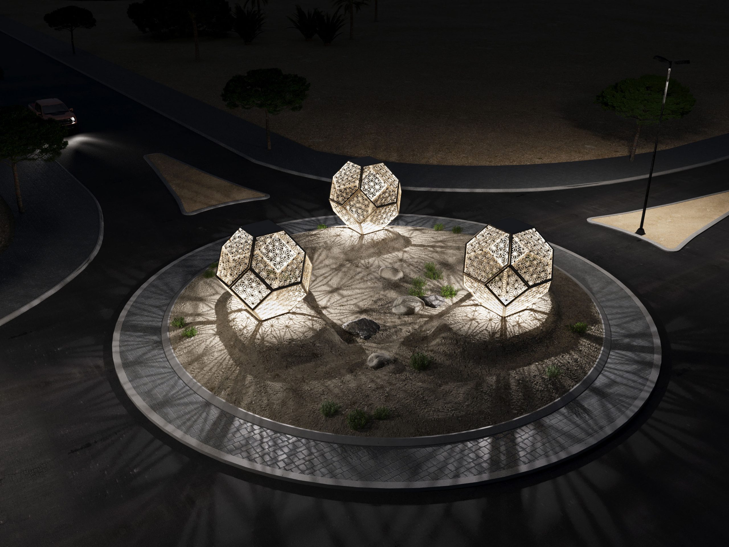 כיכר לילה מוארת במדבר, עם שלושה פסלים גאומטריים מוארים דמויי דו-דקאדרים, עשויים ממתכת עם דוגמאות חיתוך לייזר עדינות. האור החם היוצא מהם יוצר צללים מורכבים על הקרקע, המשתלבים עם צמחייה מדברית ואבנים טבעיות. הכיכר מוקפת בכביש אספלט ונתיבי גישה, ועצים בודדים נראים ברקע החשוך.