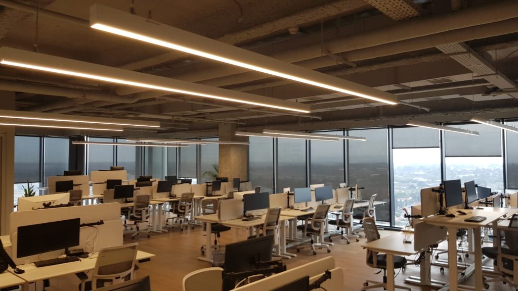 שולחנות עבודה עם מסכים וגופי תאורה מעל כל שורה.